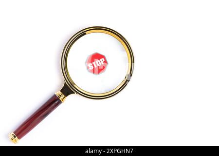 Magnifying glass with stop sign isolated on white background Stock Photo