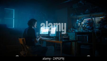 Caucasian Male Programmer Using Old Desktop Computer With Two Monitors In Retro Garage Late At Night. White Hat Hacker Searching For Software Vulnerabilities, Coding Cyber Security System In Nineties. Stock Photo