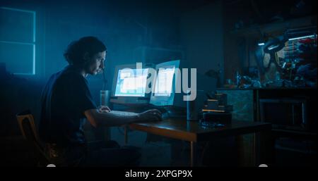 Caucasian Male Programmer Using Old Desktop Computer With Two Monitors In Retro Garage Late At Night. White Hat Hacker Searching For Software Vulnerabilities, Coding Cyber Security System In Nineties. Stock Photo