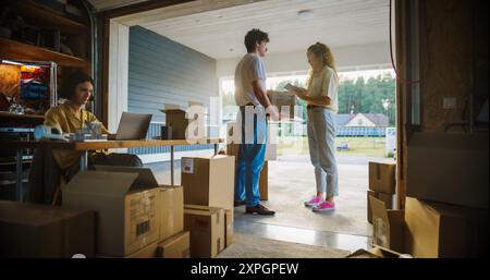 Young Hispanic Female Software Engineer Programming On Laptop Computer In Opened Garage. Woman Running A Startup With Innovative Online Solution For Businesses. Businesswoman Coding, Optimizing System Stock Photo