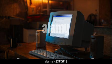 Close Up Shot Of Old Desktop Computer On Work Desk Of Software Developer In Retro Garage. Dated PC Has Operating System Terminal Opened, Prompts Running On Screen, Code Functioning Successfully. Stock Photo