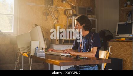 Caucasian Male Computer Engineer Coding On Old Desktop PC And Inspecting Microchip In Retro Garage. Man Starting an Innovative Computer Company In Nineties, Building New Devices. Nostalgia Concept. Stock Photo