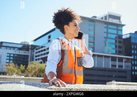 Confident Female Construction Worker Using Phone Outdoors in Modern Urban Setting Stock Photo