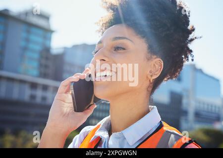 Smiling Construction Worker on Phone Call in Cityscape Stock Photo