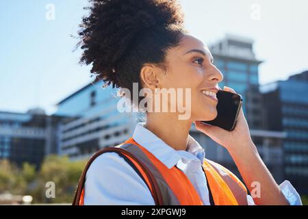 Female Engineer in Safety Vest Talking on Phone at Construction Site Stock Photo