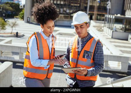 Diverse Construction Workers Reviewing Plans on a City Project Stock Photo