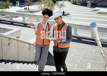 Diverse Construction Workers Discussing Project Outdoors in City Setting Stock Photo