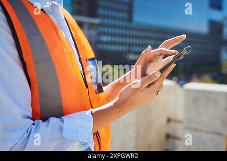 Construction Worker Using Smartphone at Urban Construction Site Stock Photo