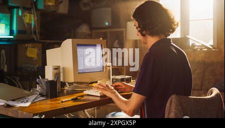 Caucasian Male Software Engineer Programming on Old Desktop Computer In Retro Garage. Focused Man Starting Fintech Startup Company In Nineties. Coding Innovative Online Service At Home. Stock Photo
