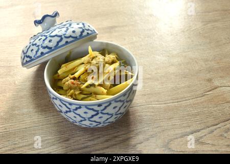 spicy boiled slice fresh bamboo shoot with pork in coconut milk curry soup on bowl Stock Photo
