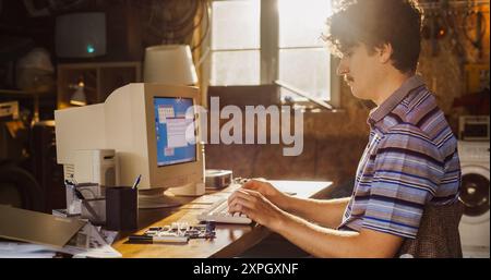 Caucasian Male Hardware Engineer Programming On Old Desktop Computer In Retro Garage. Experienced Software Developer Writing Code For New Innovative Operating System In Nineties. Stock Photo