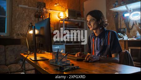 Caucasian Male Software Engineer Coding on Desktop Computer In Garage In The Evening. Man Starting Technological Startup Company. Coding Innovative Online Service At Home. Stock Photo