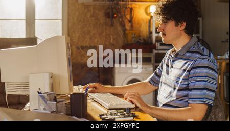 Caucasian Male Hardware Engineer Programming On Old Desktop Computer In Retro Garage. Experienced Software Developer Writing Code For New Innovative Operating System In Nineties. Stock Photo