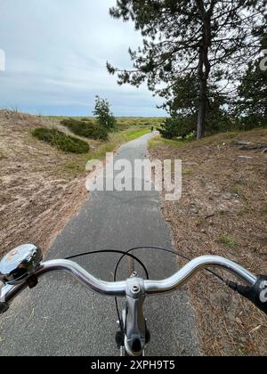 Bicycle ride through the Skagen forest. Top view of the handlebars from ...