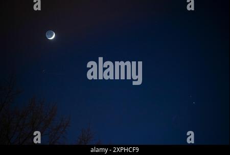 The Moon, left, Saturn, upper right, and Jupiter, lower right, are seen after sunset from Washington, DC, Thurs. Dec. 17, 2020. The two planets are dr Stock Photo