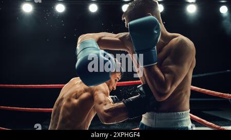 Two Male Boxers in High-stakes Match, Exchanging Powerful Blows Under Intense Lighting. Raw Energy and Fierce Competition at Boxing Championship, With Sweat Flying in Gripping Sports Moment Stock Photo