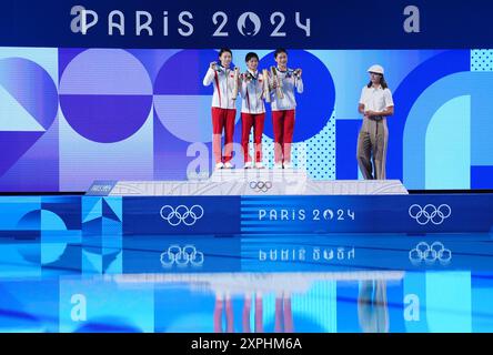 China's Quan Hongchan (centre) on the podium with the gold medal, alongside China's Chen Yuxi (left) with silver and North Korea's Kim Mi-rae with bronze after the Women's 10m Platform Final at the Aquatics Centre on the eleventh day of the 2024 Paris Olympic Games in France. Picture date: Tuesday August 6, 2024. Stock Photo