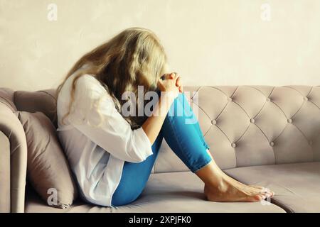 Upset sad crying woman covering eyes and face with her hands while experiencing mental suffering Stock Photo