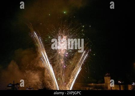 spectacular fireworks display during the Fiesta de la Anunciada in Bayona, with the historic Parador providing a stunning backdrop. The vibrant explos Stock Photo