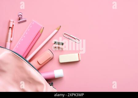 Top view of pencil case with school supplies with space for text over pink background. Back to school concept Stock Photo