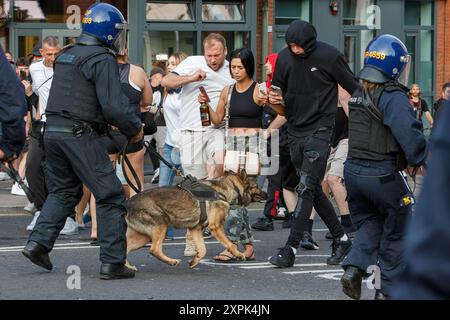 Bristol riot -  Police use police dogs to control and push back Far-right activists during an Enough is Enough protest in Bristol. 03-08-2024 Stock Photo