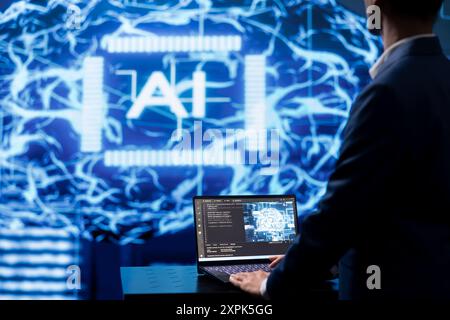 Programmer using AI cognitive computing to extract usable information from complex data on laptop. Employee using artificial intelligence tech on notebook to accelerate complex calculations Stock Photo
