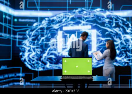 AI engineers using isolated screen device for business data analysis. IT department staff members work on chroma key notebook to automatize tasks using artificial intelligence Stock Photo