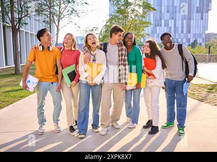 Group generation z international university students laughing standing hugging together on campus. Stock Photo