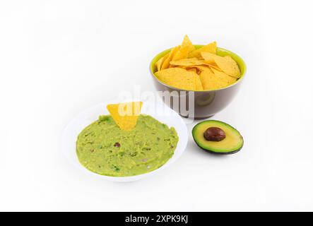Bowl of guacamole and nachos on white background. Stock Photo