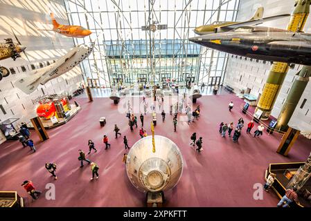 WASHINGTON DC, United States — Elevated view of the main foyer inside the entrance at the Smithsonian Institution's National Air and Space Museum on the National Mall in Washington DC. The lunar module at the bottom of the frame is the original Apollo XI re-entry vehicle, while the orange plane at top left was Chuck Yeager's Bell X-1 aircraft in which he broke the sound barrier for the first time in level flight. The Air and Space Museum, which focuses on the history of aviation and space exploration, is one of the most visited museums in the world. Stock Photo