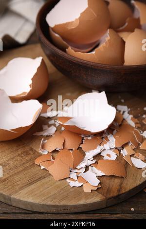 Pieces of broken eggshells on wooden table, closeup Stock Photo