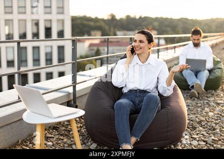 Business professionals working remotely on outdoor rooftop lounge Stock Photo