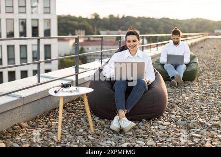 Outdoor workspace with professionals working on laptops Stock Photo