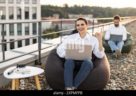 Remote working on rooftop with laptops and bean bags Stock Photo