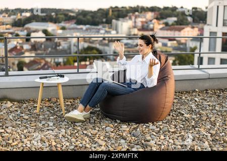 Woman working on rooftop enjoying outdoor office space Stock Photo
