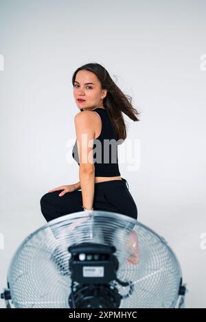 girl sitting in front of a fan Stock Photo