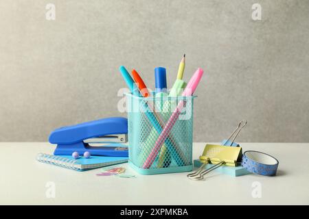 Stapler, holder and other different stationery on white table Stock Photo