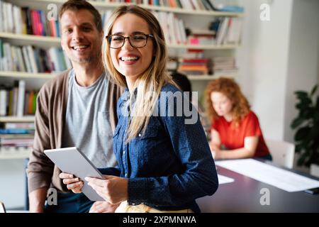 Two young businesspeople using a digital tablet while standing in a boardroom. Stock Photo