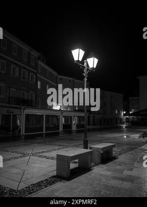 Cres, Croatia - October 23, 2022: Street in Cres with old streetlamps during night, black and white Stock Photo