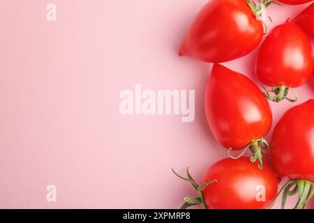 Red cherry tomatoes on a pink background. Stock Photo