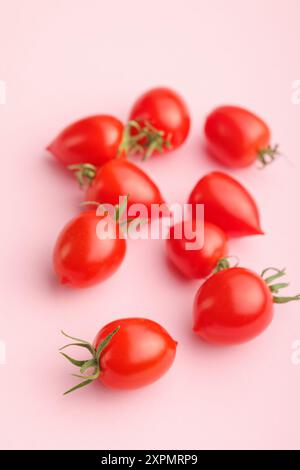 Red cherry tomatoes on a pink background. Stock Photo