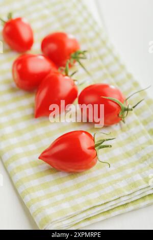 Red cherry tomatoes on a checkered napkin. Stock Photo