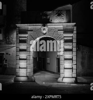 Cres, Croatia - October 23, 2022: Old city wall gate in the night, black and white Stock Photo