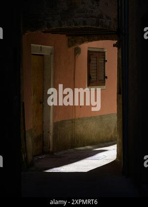 Cres, Croatia - October 23, 2022: Narrow street in Cres sunlight and shadow Stock Photo