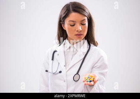 Portrait of female doctor who is holding pills in her hand. Stock Photo