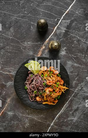 Black rice noodle pasta with squid and tomato Stock Photo - Alamy