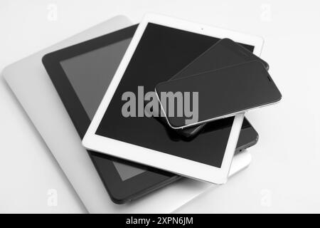 Stack of different modern gadgets on light background Stock Photo