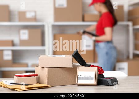 Parcel boxes with packing tape dispenser on table at postal warehouse Stock Photo