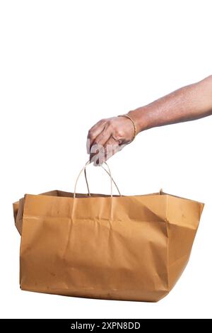 Hand holding shopping brown paper bag isolated on white background with clipping path. Closeup Stock Photo