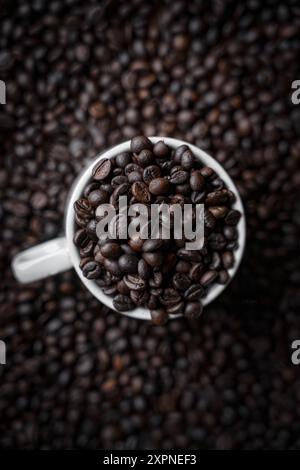 Coffee beans filled in a Coffee mug with Coffee beans in background, Tob view, Stock Photo